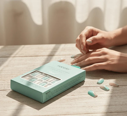 Mint glitter press-on nails worn on a hand